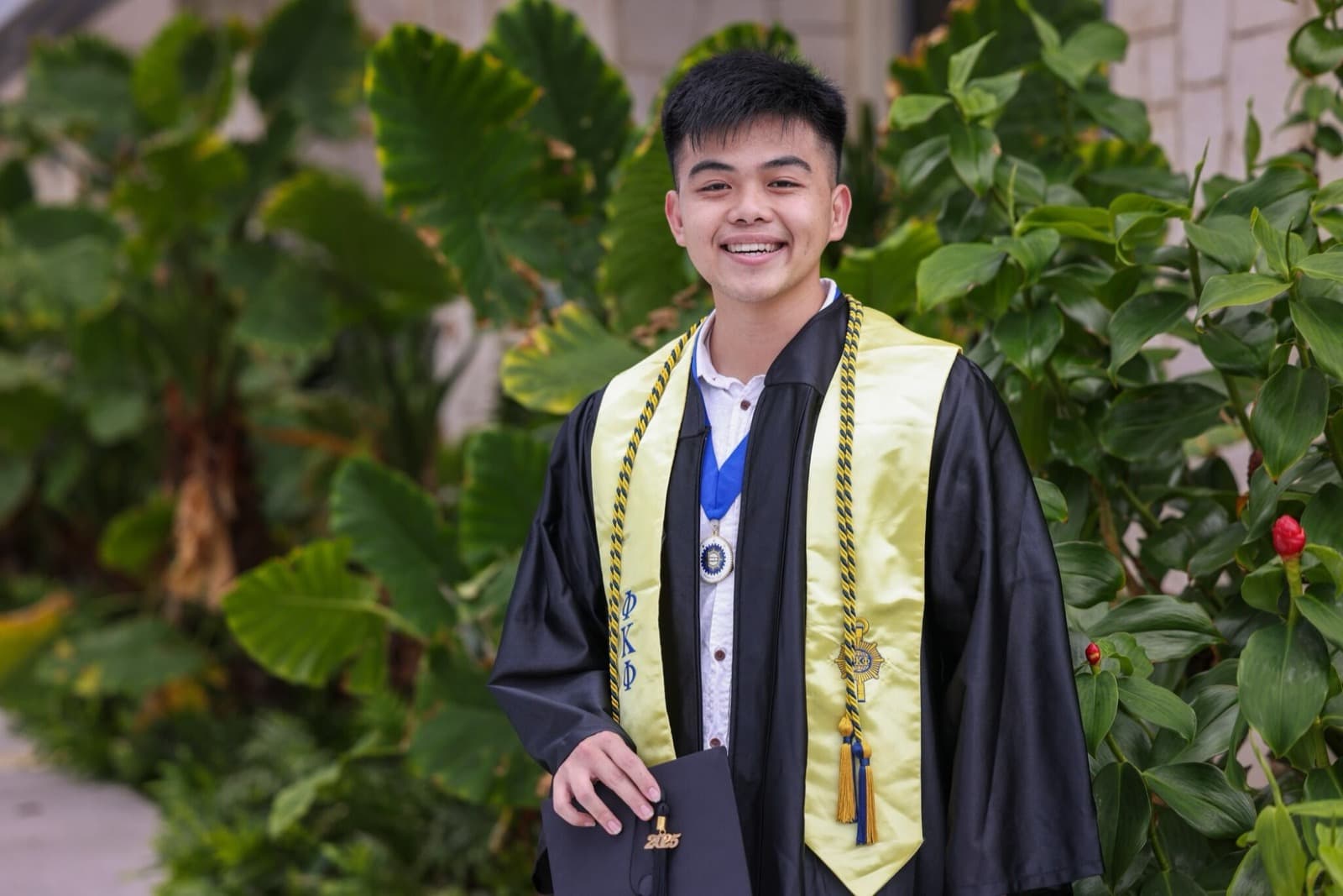Graduation portrait, April 2025, wearing the Phi Kappa Phi stole and honor cords